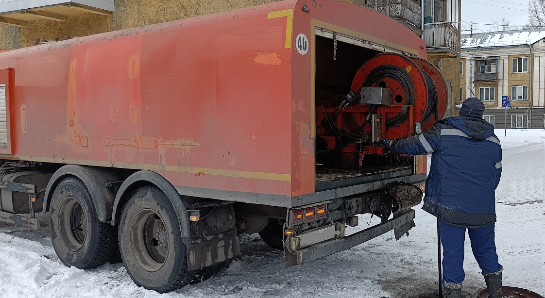 Каналопромывочная машина и работник прочищают засор в канализационной системе в Кирове